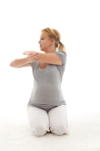 Piękna kobieta w ciąży robi ćwiczenia rozciągające — Zdjęcie stockowe