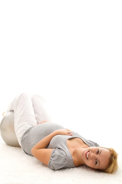 Вагітна жінка розслабляється на підлозі після вправ — стокове фото