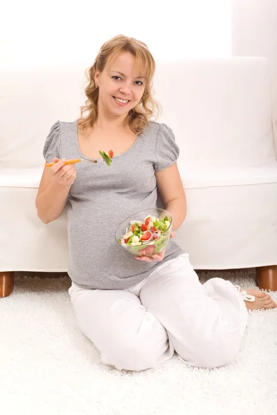 Schöne schwangere Frau isst Salat — Stockfoto