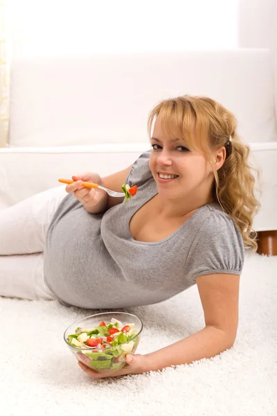 Piękna kobieta w ciąży jedzenie świeże sałatki — Zdjęcie stockowe