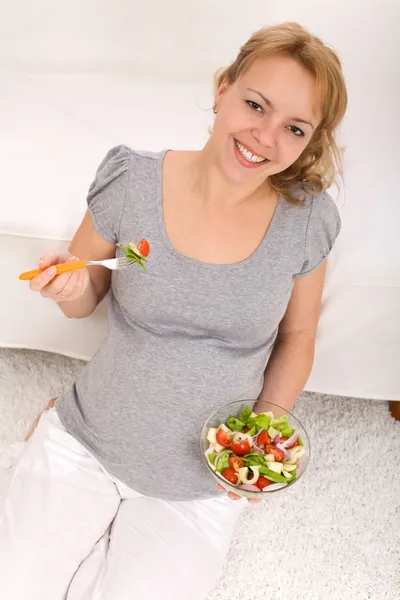 Feliz mujer embarazada comiendo ensalada fresca — Foto de Stock