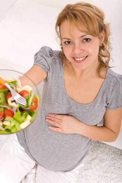Mulher grávida segurando uma tigela de salada — Fotografia de Stock