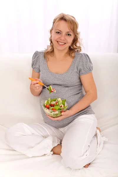 Gravid kvinde spiser grøntsager salat - Stock-foto