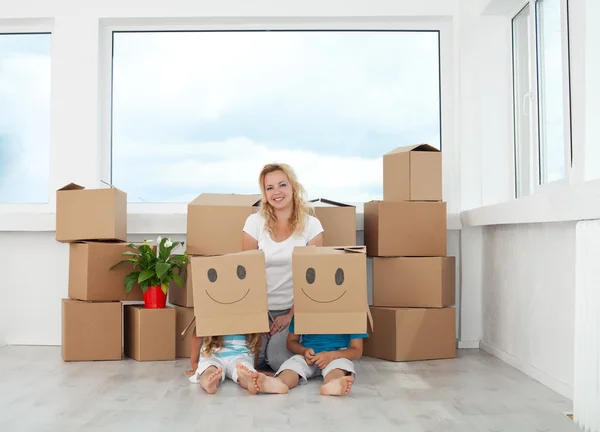 Woman with playing kids in their new home — Stock Photo, Image