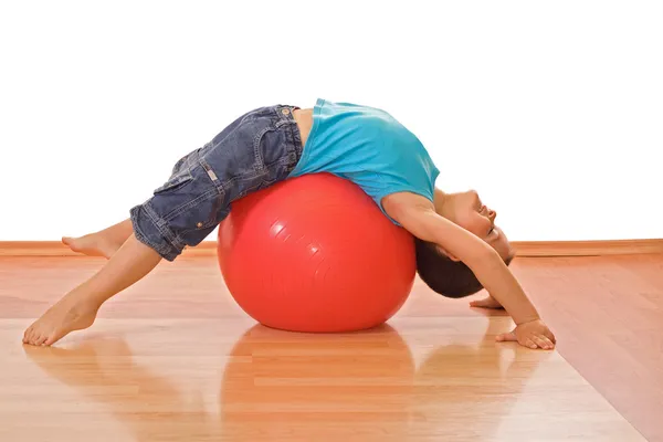Fiú játszik a gimnasztikai labda귀여운 소년 빨간 사과 균형 — Stock Fotó