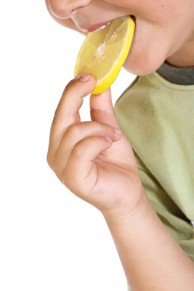 Fechar-se de criança comendo fatia de limão — Fotografia de Stock