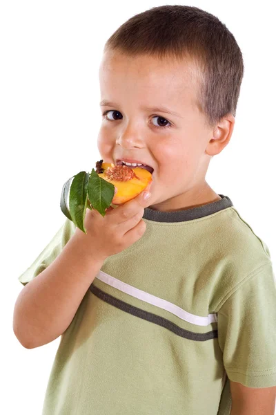 Junge isst Pfirsich — Stockfoto