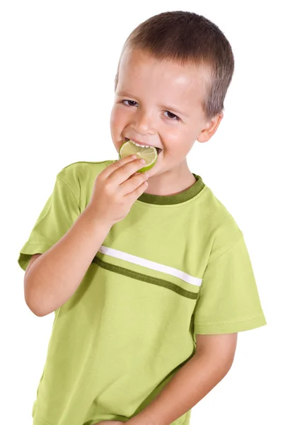 Junge isst Limettenscheibe — Stockfoto