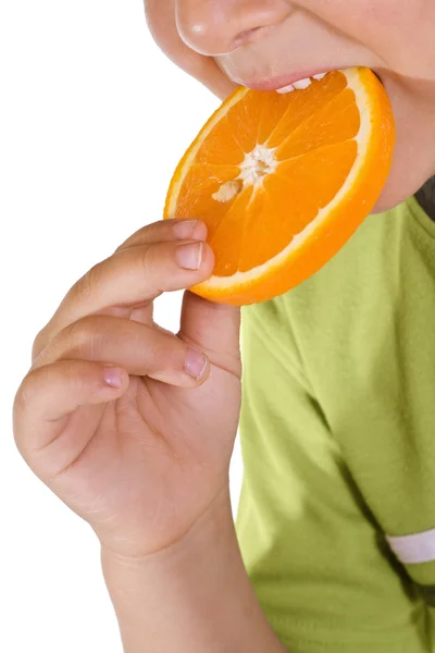 Menino comendo fatia de laranja - close-up — Fotografia de Stock