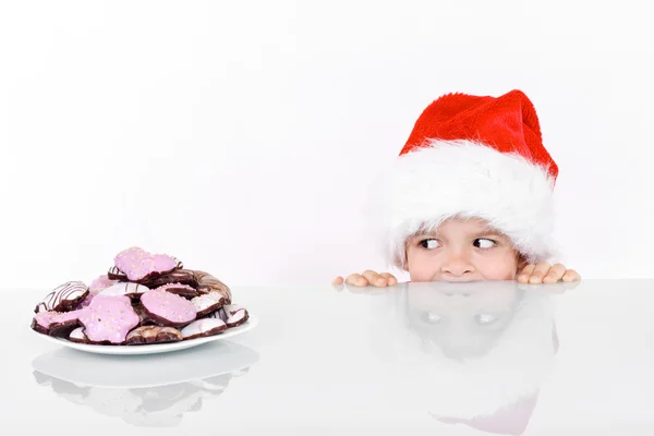 Menino espreitando os biscoitos de gengibre de Natal — Fotografia de Stock