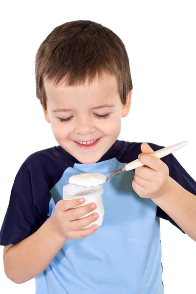 Щасливий здоровий хлопчик їсть йогурт — стокове фото