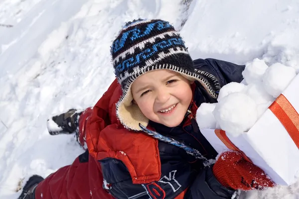Enfant heureux avec des boules de neige dans une boîte — Photo