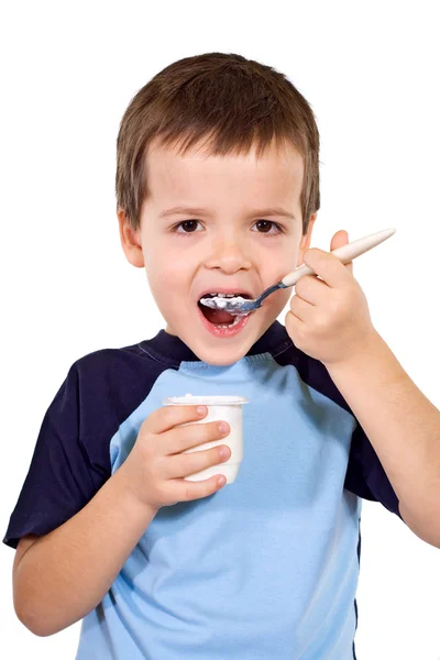 Маленький хлопчик їсть йогурт — стокове фото