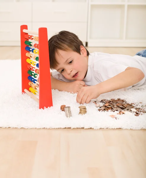 Pequeño niño contando sus ahorros — Foto de Stock