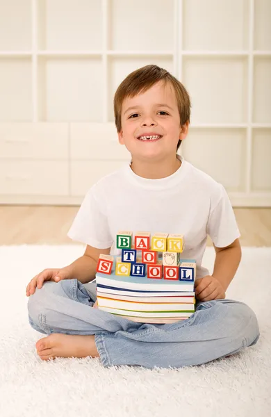 Gelukkig lachen jongen met ontbrekende tand en boeken — Stockfoto