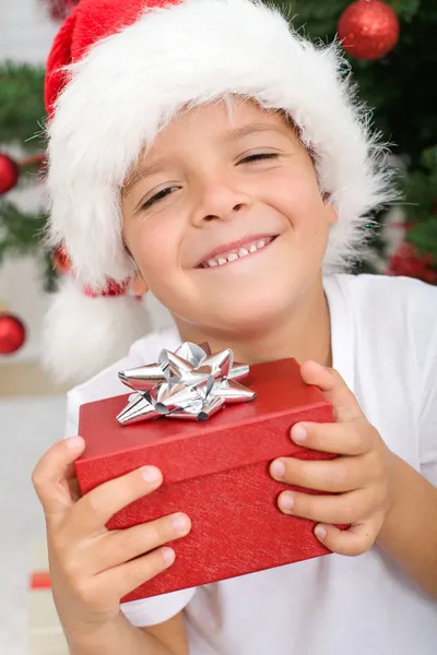 Счастливый мальчик с рождественским подарком — стоковое фото