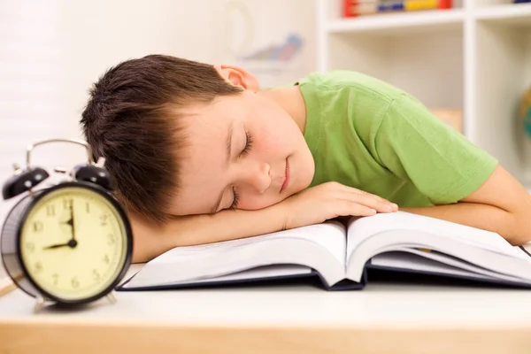 Мальчик заснул на своей книге во время учебы — стоковое фото