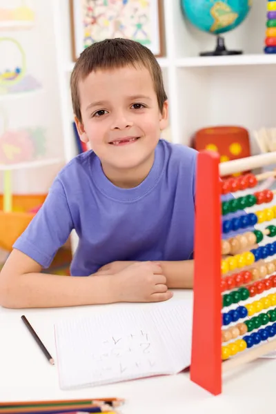 Criança feliz resolvendo exercício matemático — Fotografia de Stock