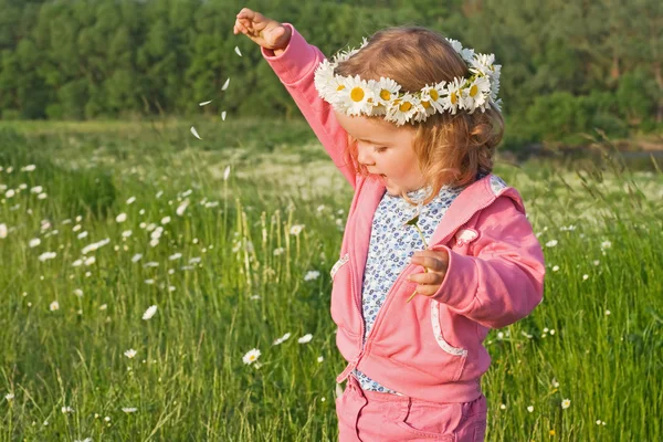 Little girl playing with flower petals — Stock Photo, Image