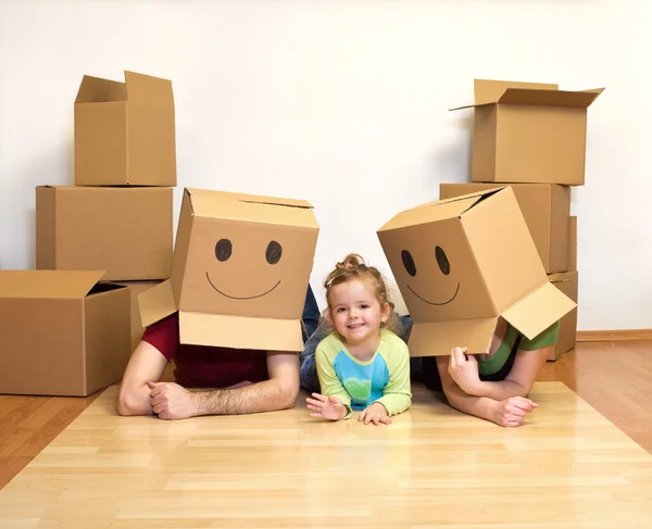 Familie spelen met karton dozen in hun nieuwe huis — Stockfoto
