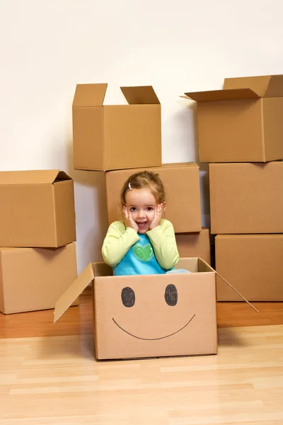 Menina em caixa de papelão - conceito em movimento — Fotografia de Stock