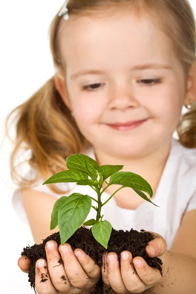 Ευτυχισμένη κοριτσάκι που κρατάει ένα νέο φυτό με χώμα — Φωτογραφία Αρχείου
