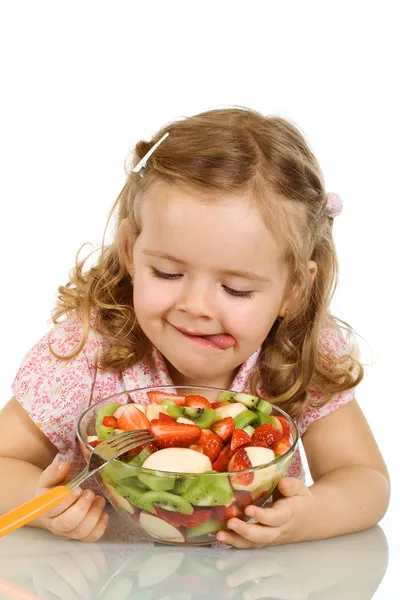 Маленькая девочка собирается попробовать фруктовый салат — стоковое фото