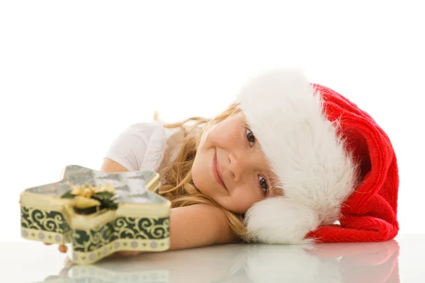 Девушка опирается на стол с рождественской коробкой печенья — стоковое фото