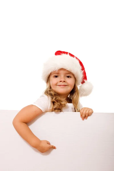 Christmas hat girl pointing to white banner — Stock Photo, Image