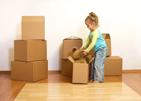 Excited little girl unpacking in her new home — Stock Photo, Image