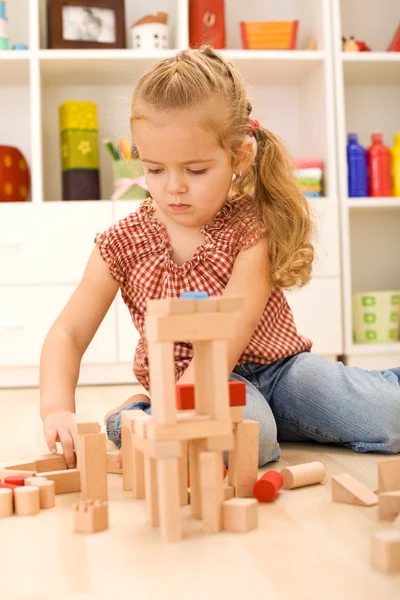 Ребенок играет с блоками на полу — стоковое фото