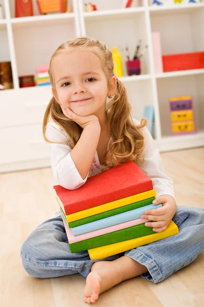 Liten flicka med en trave böcker — Stockfoto