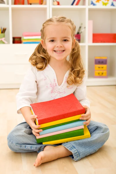 Heureuse petite fille avec des livres — Photo