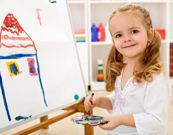 Маленька дівчинка-художник пишається своєю роботою — стокове фото