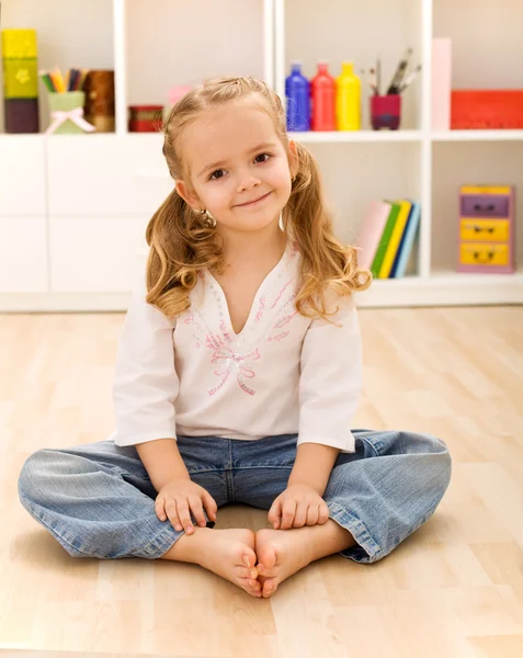 Счастливая здоровая девочка, сидящая на полу — стоковое фото