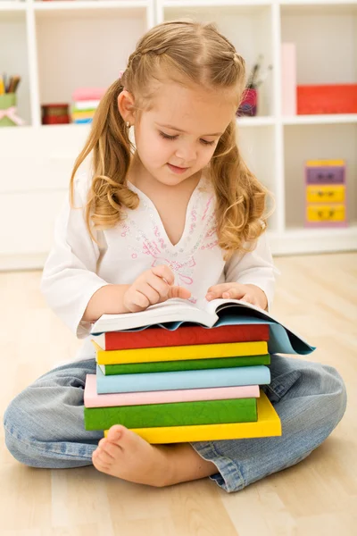 Kleines Mädchen mit vielen Büchern — Stockfoto