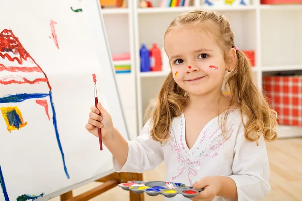 Счастливая маленькая художница - девушка, рисующая дом — стоковое фото