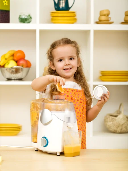 Lilla flickan att göra färsk fruktjuice — Stockfoto