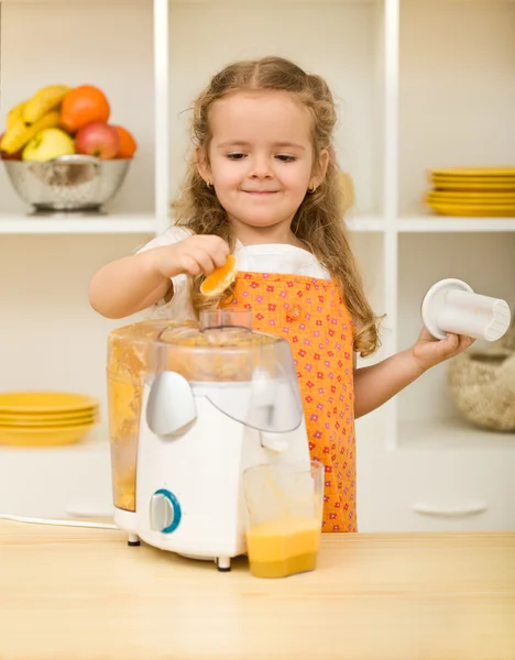 Little girl making fruit juice — Stock Photo, Image
