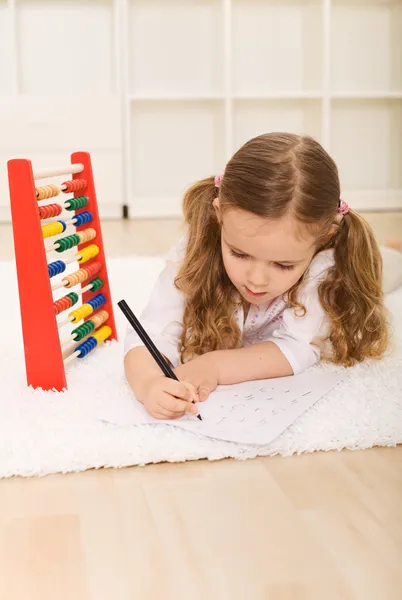 Маленькая девочка делает простые математические упражнения — стоковое фото