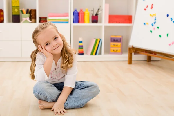 Glückliches kleines Mädchen in ihrem Zimmer sitzend — Stockfoto