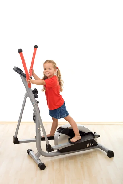 Little girl on elliptical trainer — Stock Photo, Image