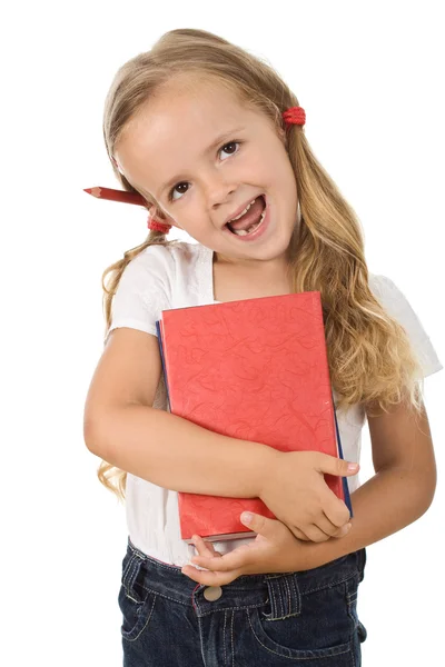 Kitap ve kulağın arkasına kurşun kalem ile mutlu küçük kız — Stok fotoğraf