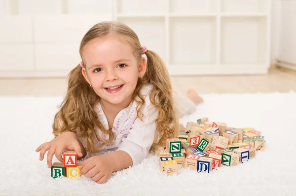 Κοριτσάκι με ξύλινα μπλοκ αλφάβητο αναπαραγωγή — Φωτογραφία Αρχείου
