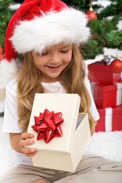 Klein meisje openen kerstcadeau — Stockfoto