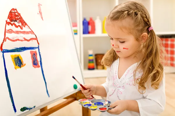 Little artist girl painting on large paper canvas — Stock Photo, Image