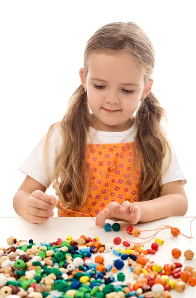 Kislány játszó string és gyöngyök — Stock Fotó