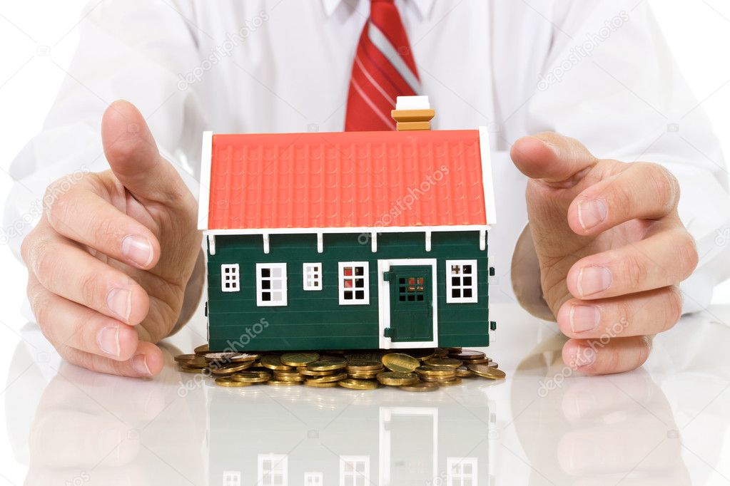 House on golden coins pile with businessman hands