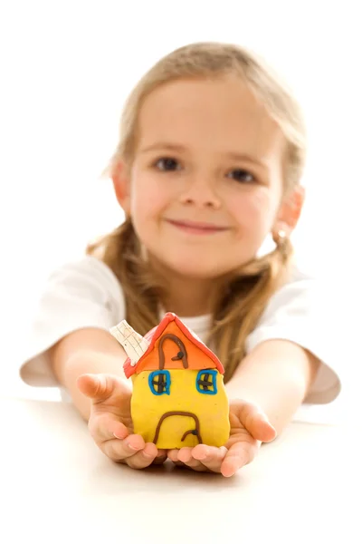 Маленькая девочка держит глиняный дом — стоковое фото