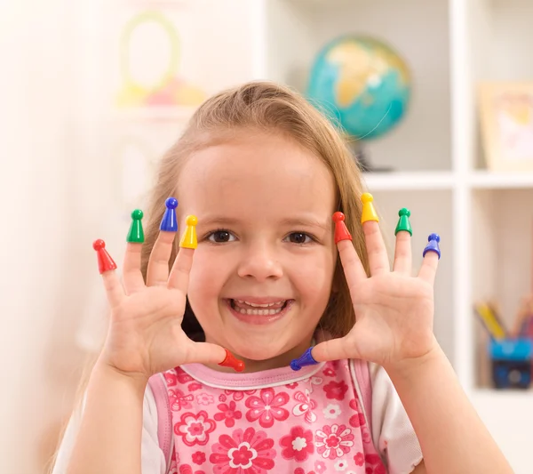 Маленька дівчинка грає з ігровими фігурами — стокове фото